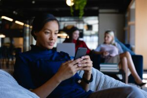 African American woman using her phone in modern office